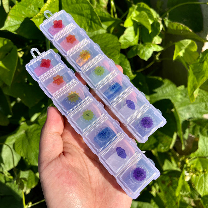Set of tumbled healing stones for each chakra, arranged by color in a labeled crystal storage box.