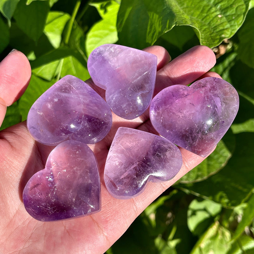 Polished amethyst heart crystal with translucent purple tones.