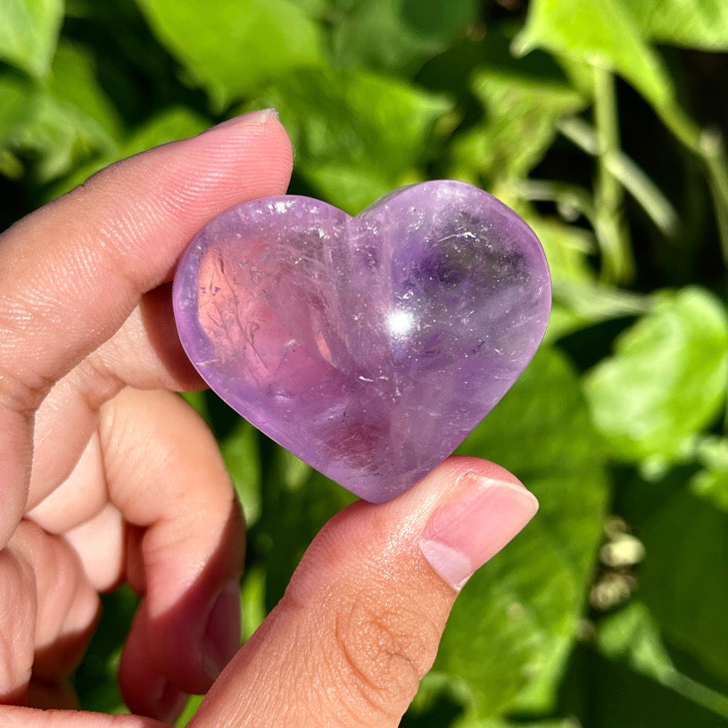 Purple quartz crystal heart with smooth surface and gentle glow