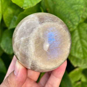 Round rainbow moonstone crystal with soft glow and flash, ideal for meditation and display.