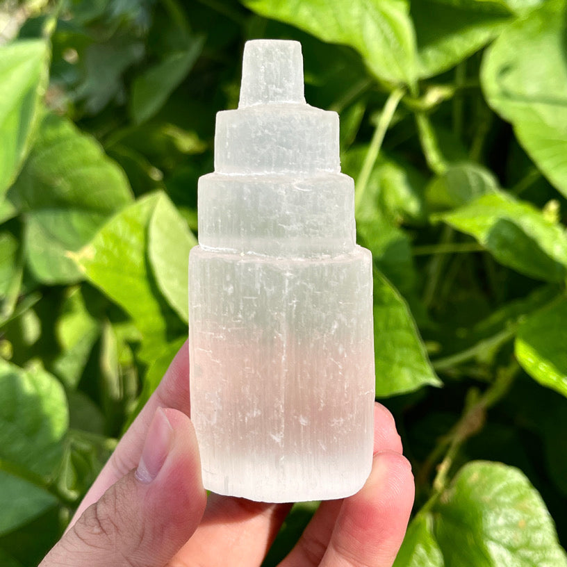 Layered selenite tower carving with translucent white glow