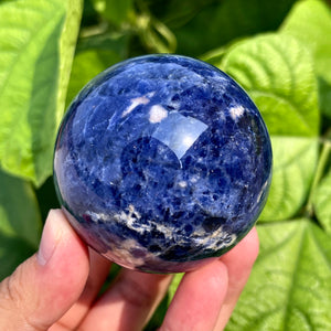 Polished sodalite sphere with deep blue and white marbling