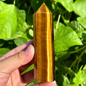 Tiger’s eye gemstone obelisk with layered stripes and pointed top