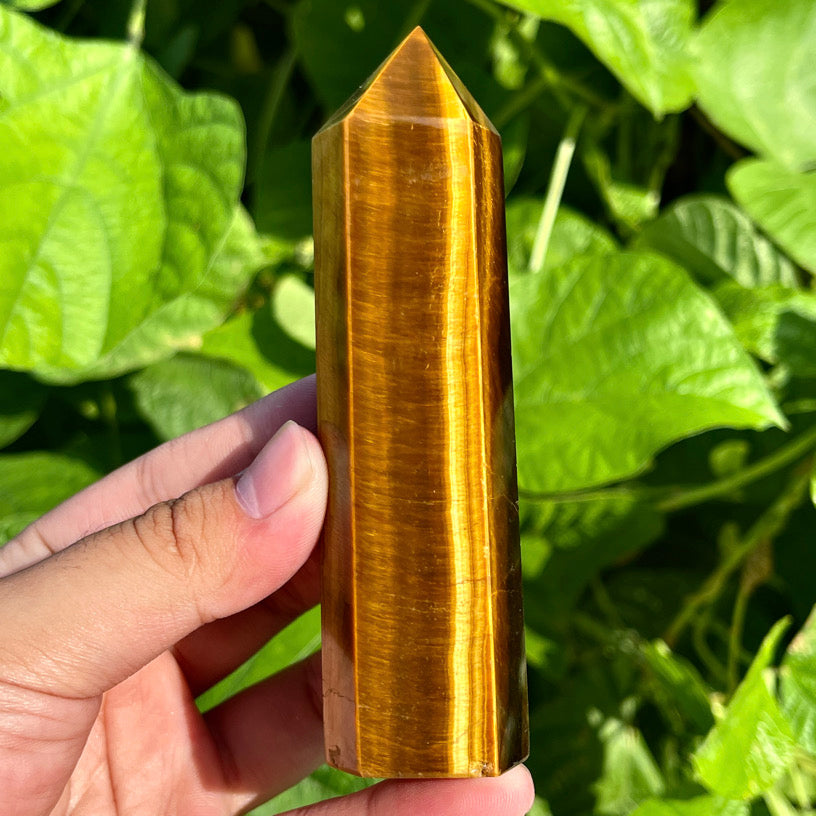 Tiger’s eye gemstone obelisk with layered stripes and pointed top