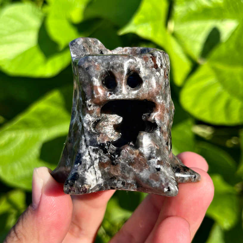 UV-reactive Yooperlite treant sculptures with fiery glow effects, captured in a dark setting.