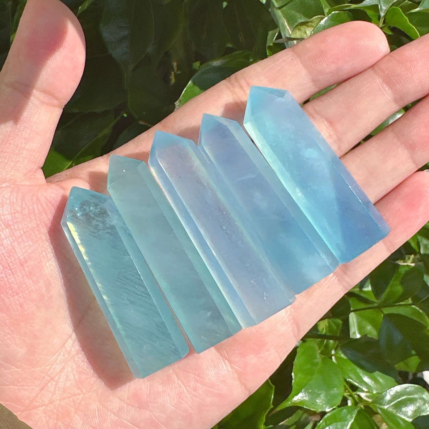 Aquamarine crystal tower with a smooth and polished finish, radiating soft blue tones.