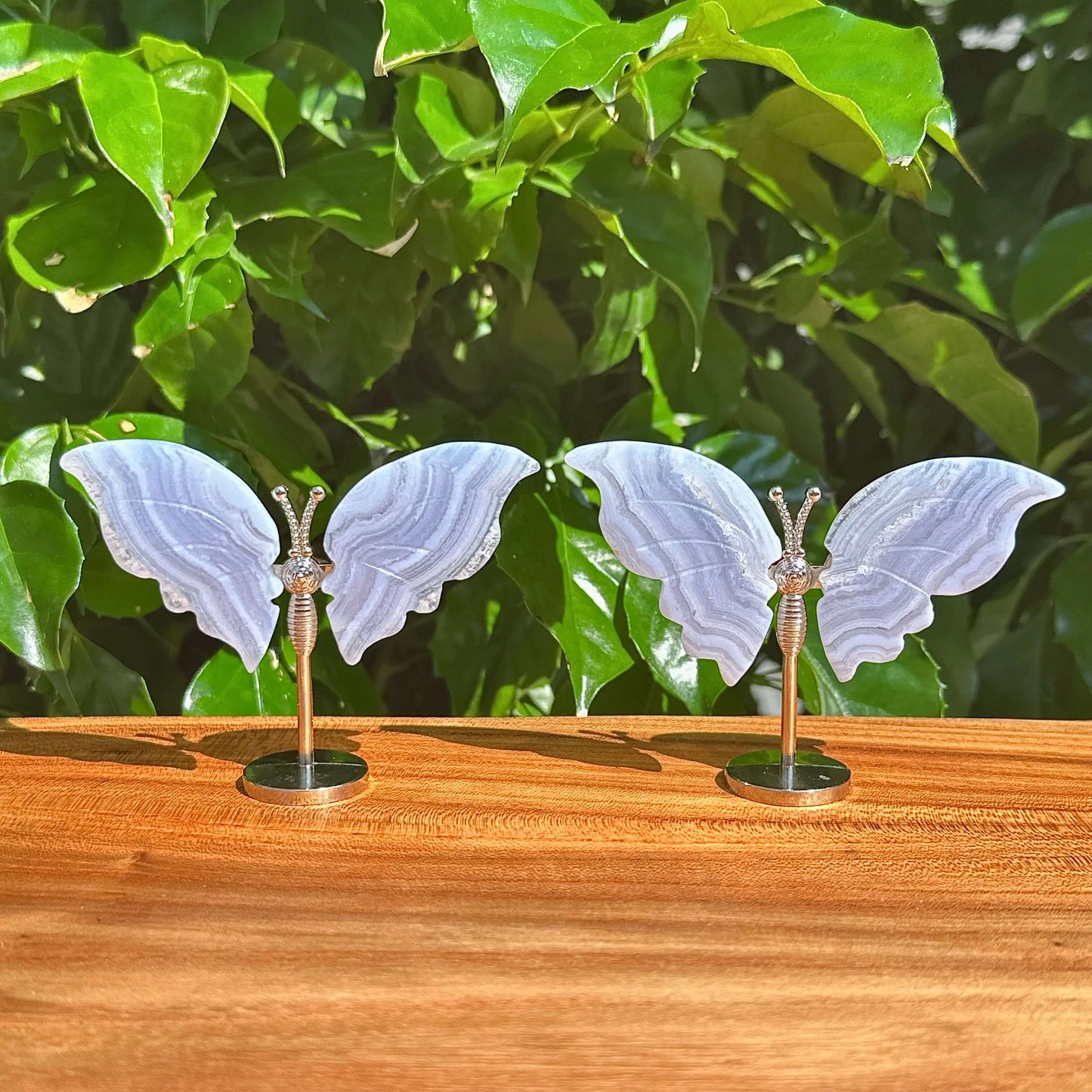 Front view of Blue Lace Agate butterfly with translucent wings, featuring a silver body and base.