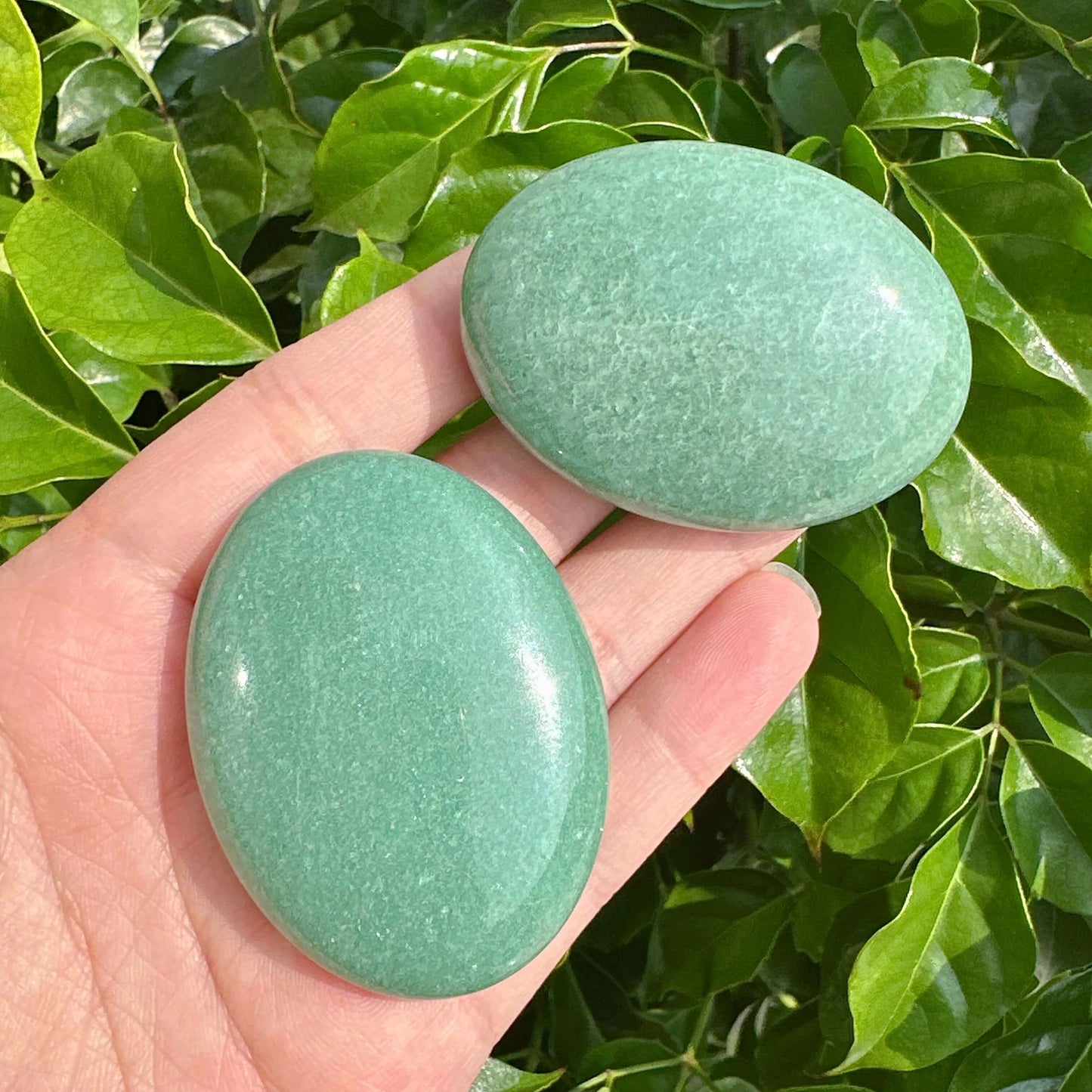 Close-up of a Green Aventurine Palm Stone with a polished, vibrant finish.
