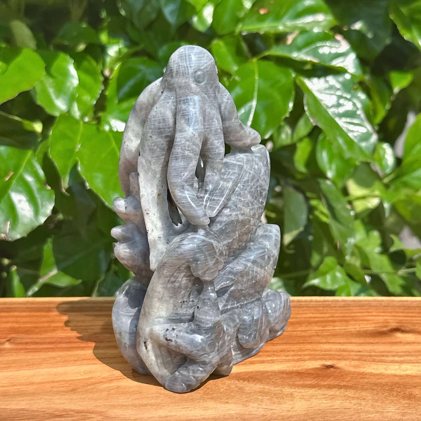 Labradorite octopus carving held in hand with a close-up on the fine craftsmanship.