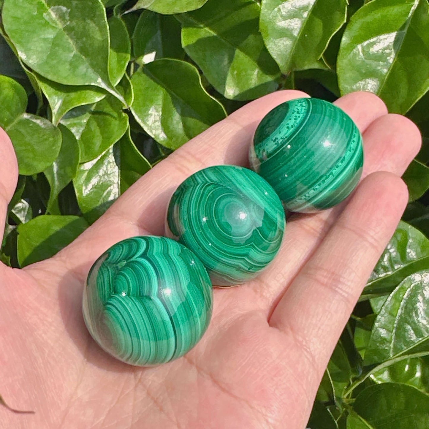 Malachite gemstone sphere with polished surface and vibrant green tones