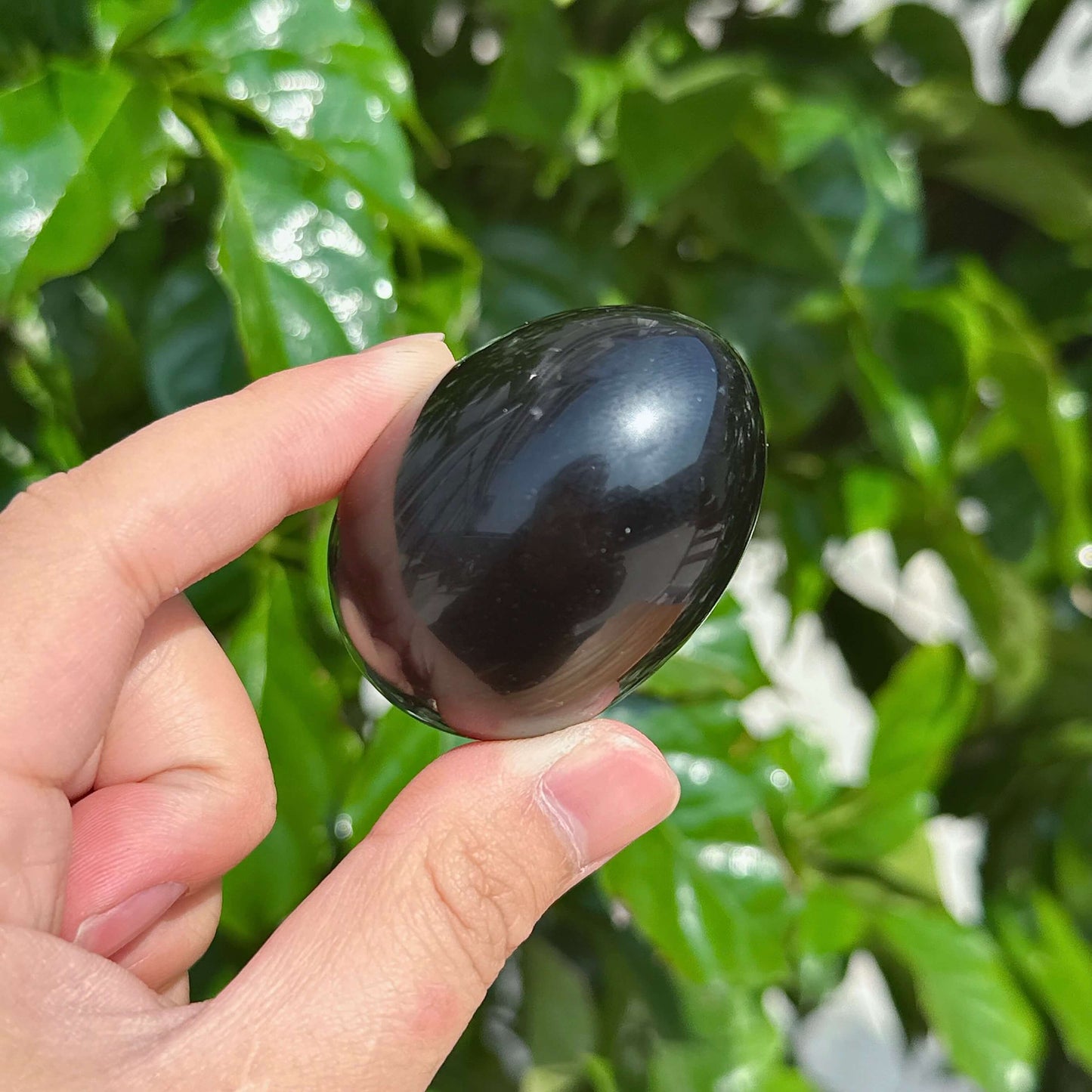 Glossy obsidian egg carving with smooth texture, a great addition to any crystal art collection.