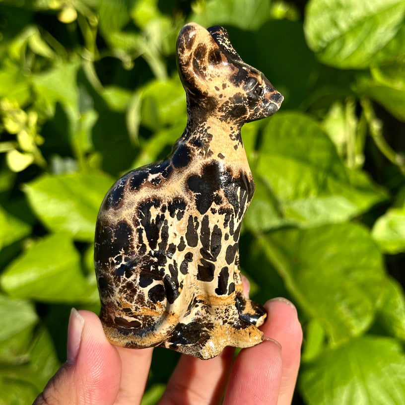 Single hand-carved picture jasper cat statue with spotted patterns and upright ears, shown in profile view.