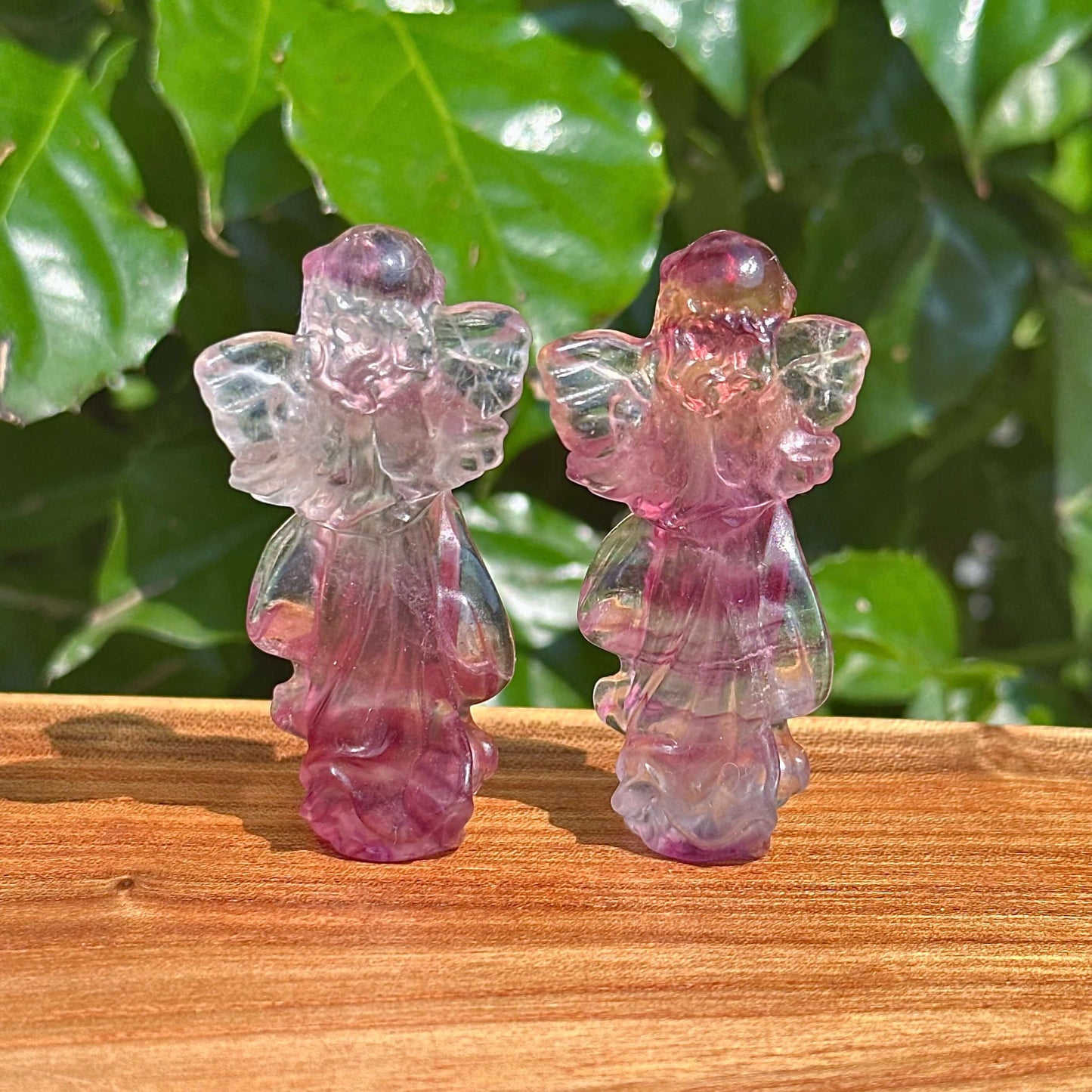 A set of Rainbow Fluorite angel carvings showcasing vibrant wings and serene facial expressions.
