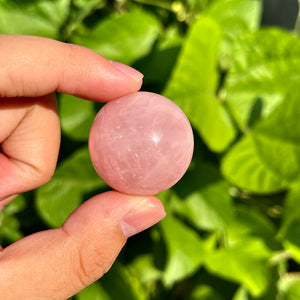 Rose quartz sphere with soft pink hue and polished surface