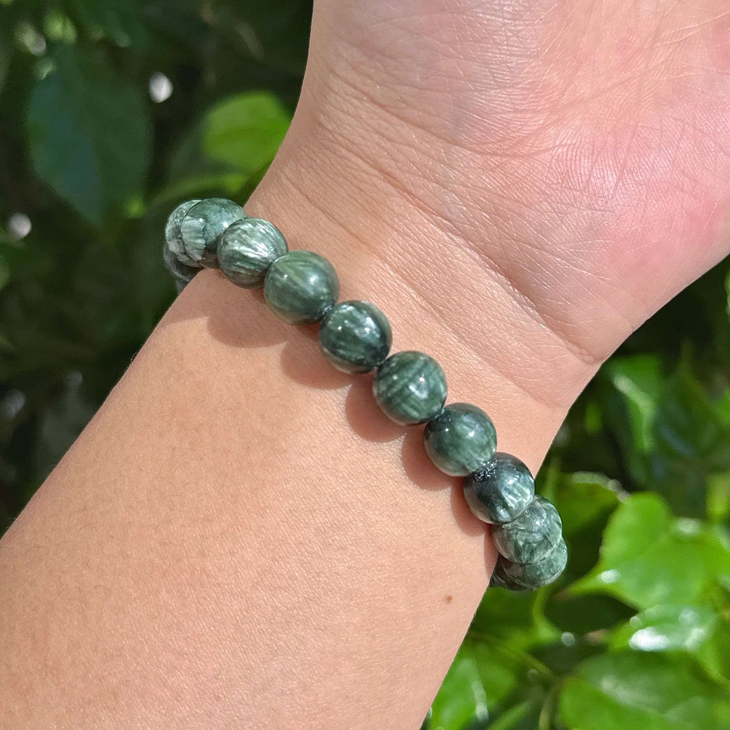Multiple Seraphinite bracelets stacked together, highlighting the calming energy of natural gemstones.