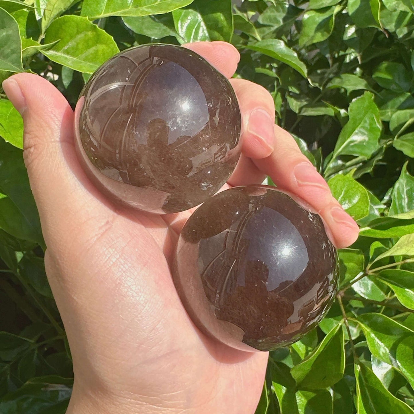 Smoky Quartz Sphere with a reflective surface, highlighting its calming and protective energy for spiritual work.