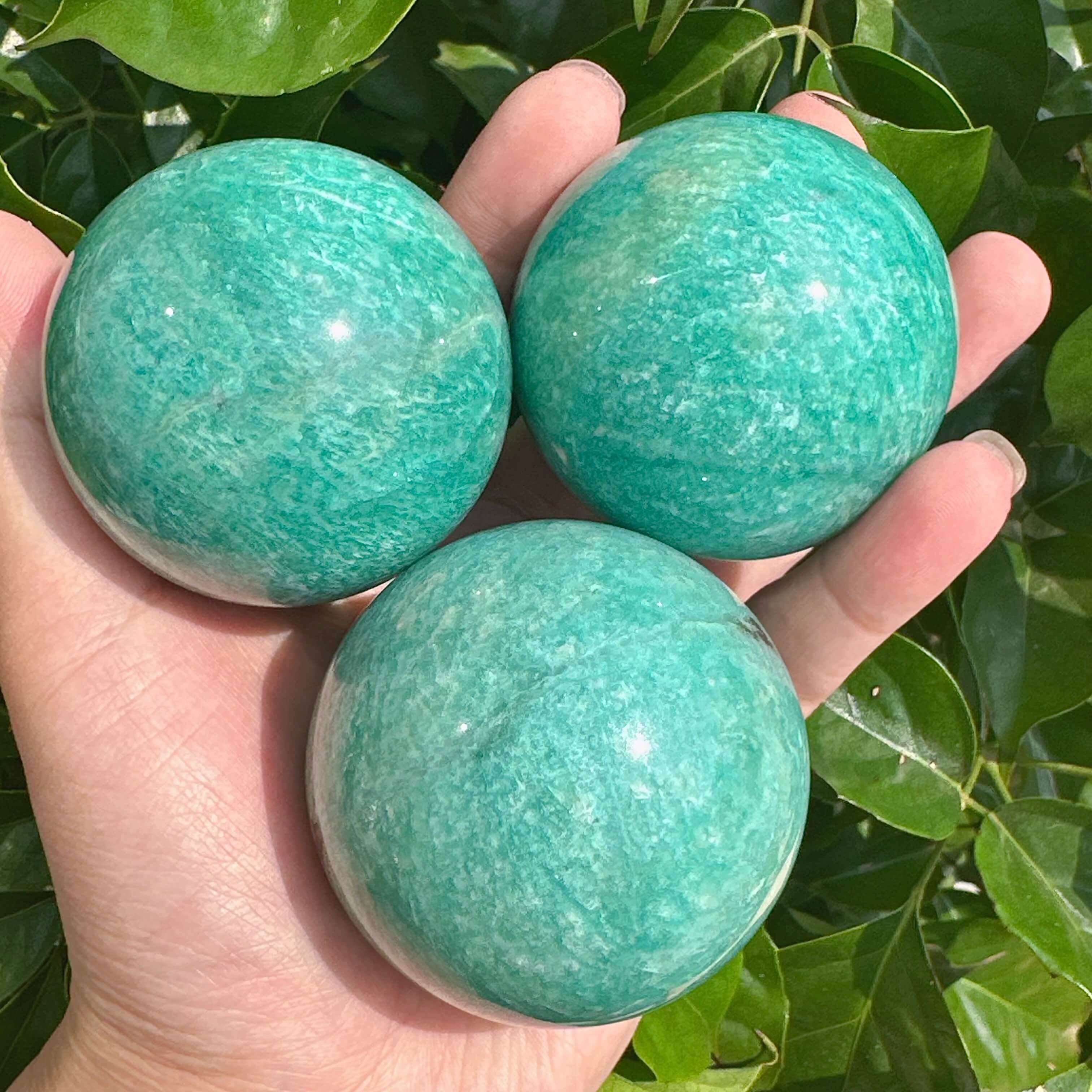 Amazonite sphere with vibrant green and blue hues, showcasing its polished surface.