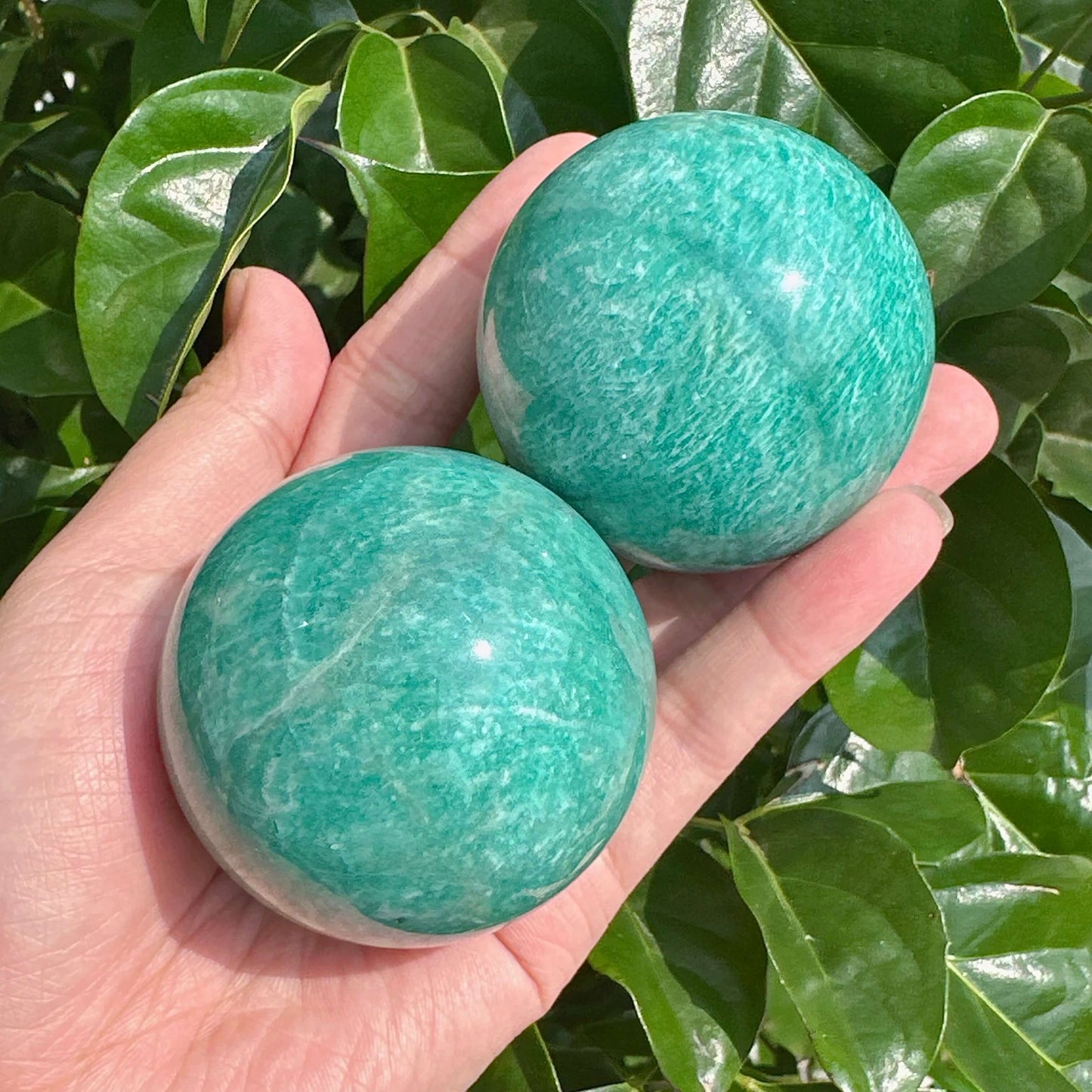 Large Amazonite sphere featuring its calming green and blue tones, ideal for display or spiritual practices.