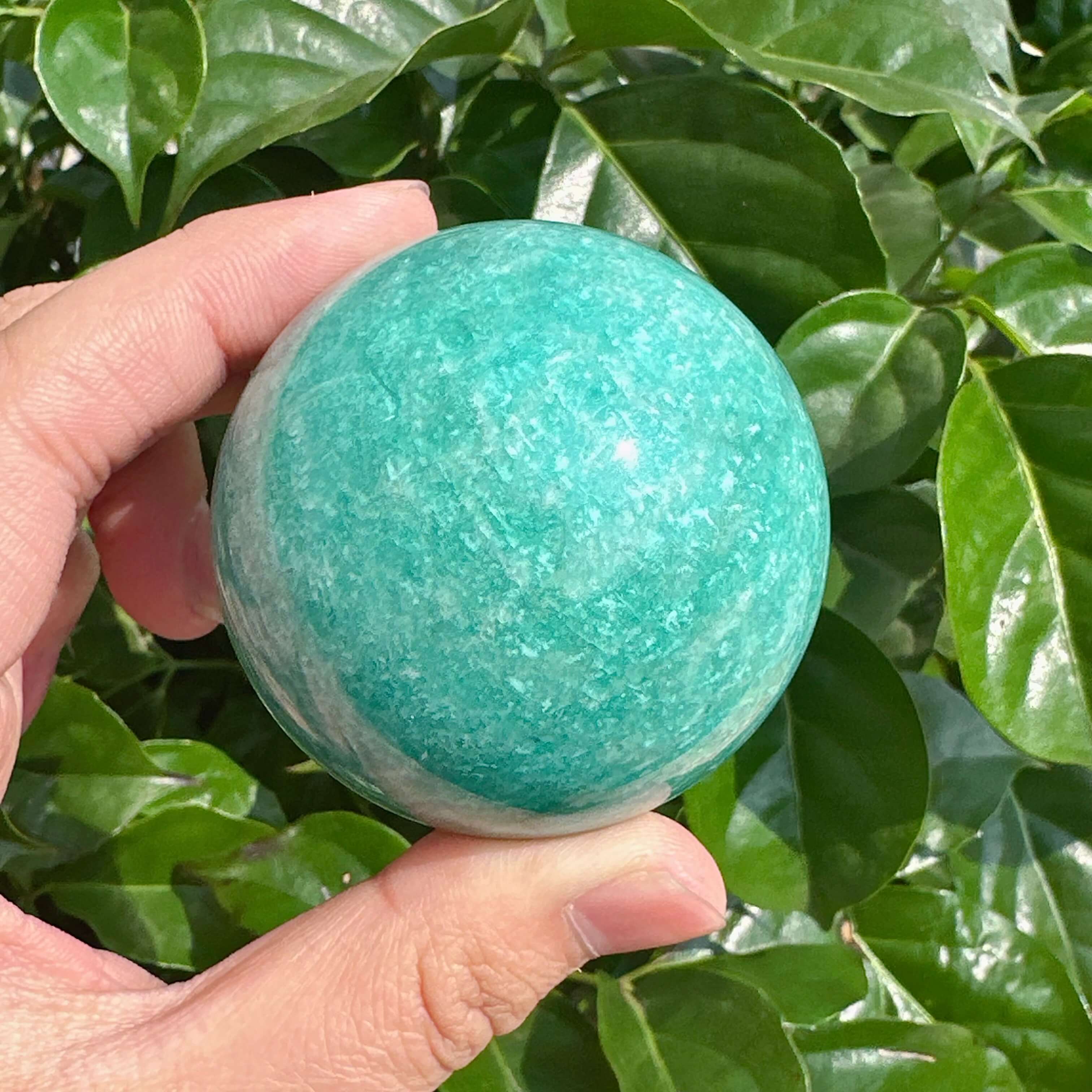 Polished Amazonite sphere with a shiny, smooth surface, offering balance and tranquility.