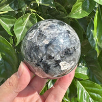 Larvikite Sphere with distinctive shimmering appearance, displaying natural gray and black tones, perfect for energy healing and crystal collections.
