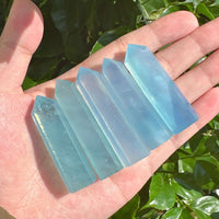 Aquamarine crystal tower with a smooth and polished finish, radiating soft blue tones.