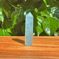 Aquamarine crystal tower displayed in natural light, showcasing its calming blue and green hues.
