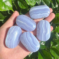 Side view of Blue Lace Agate Palm showcasing smooth, polished surface and natural crystal formations.