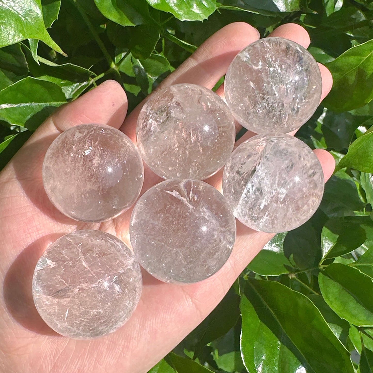 Clear Quartz Sphere showcasing its transparent beauty and natural crystal formations, radiating clarity and energy.