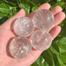 Clear Quartz Spheres, each displaying unique inclusions and shimmering light, perfect for home decor and energy work.