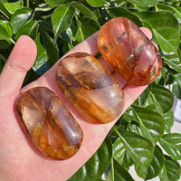 A stunning Golden Healer Palm stone in hand, reflecting the natural golden colors and energy of the crystal.