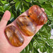 A stunning Golden Healer Palm stone in hand, reflecting the natural golden colors and energy of the crystal.