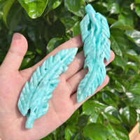 Stunning Hemimorphite Feather Carving with natural texture and vibrant blue hues.