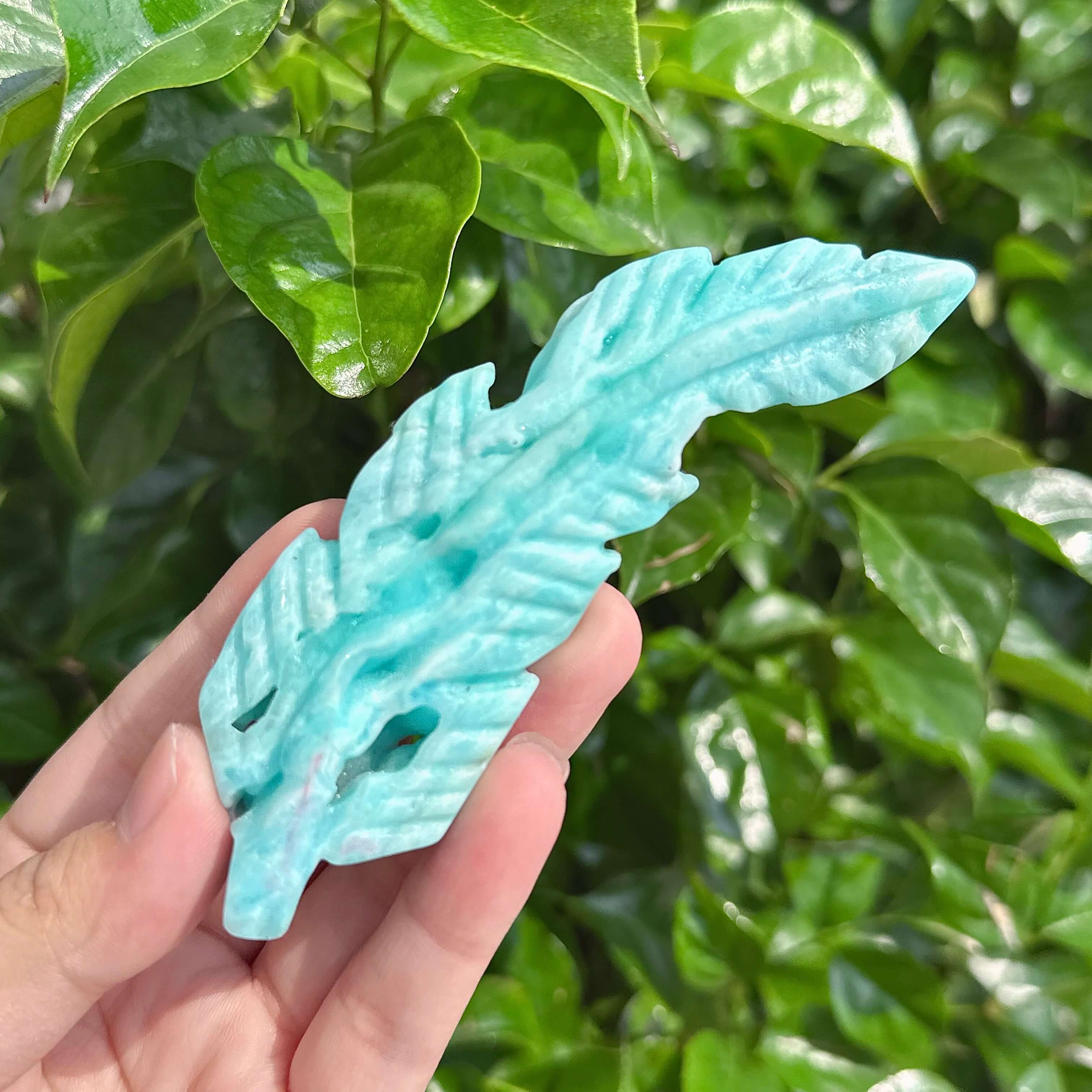 Hemimorphite Feather Carving highlighting the crystal's smooth surface and fine craftsmanship.