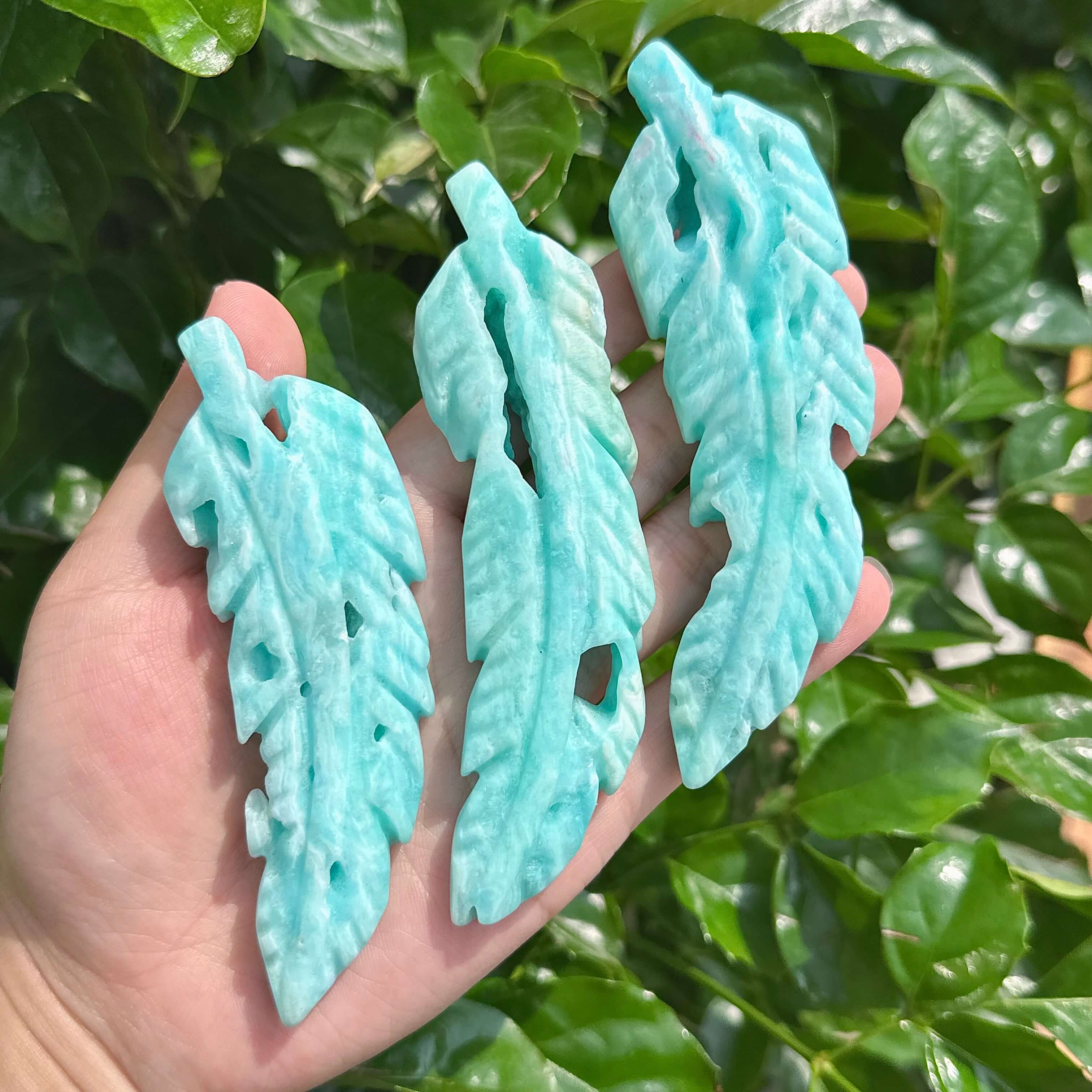 Hemimorphite Feather Carving captured in natural lighting, showing the unique variations of color and texture.