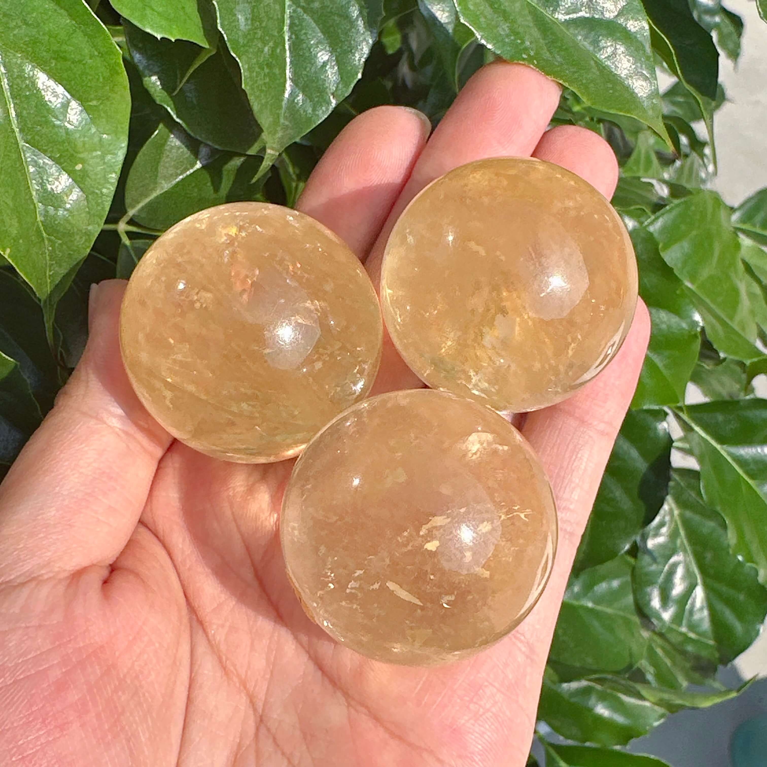 Angled view of Honey Calcite Sphere, emphasizing its polished finish and luminous glow.