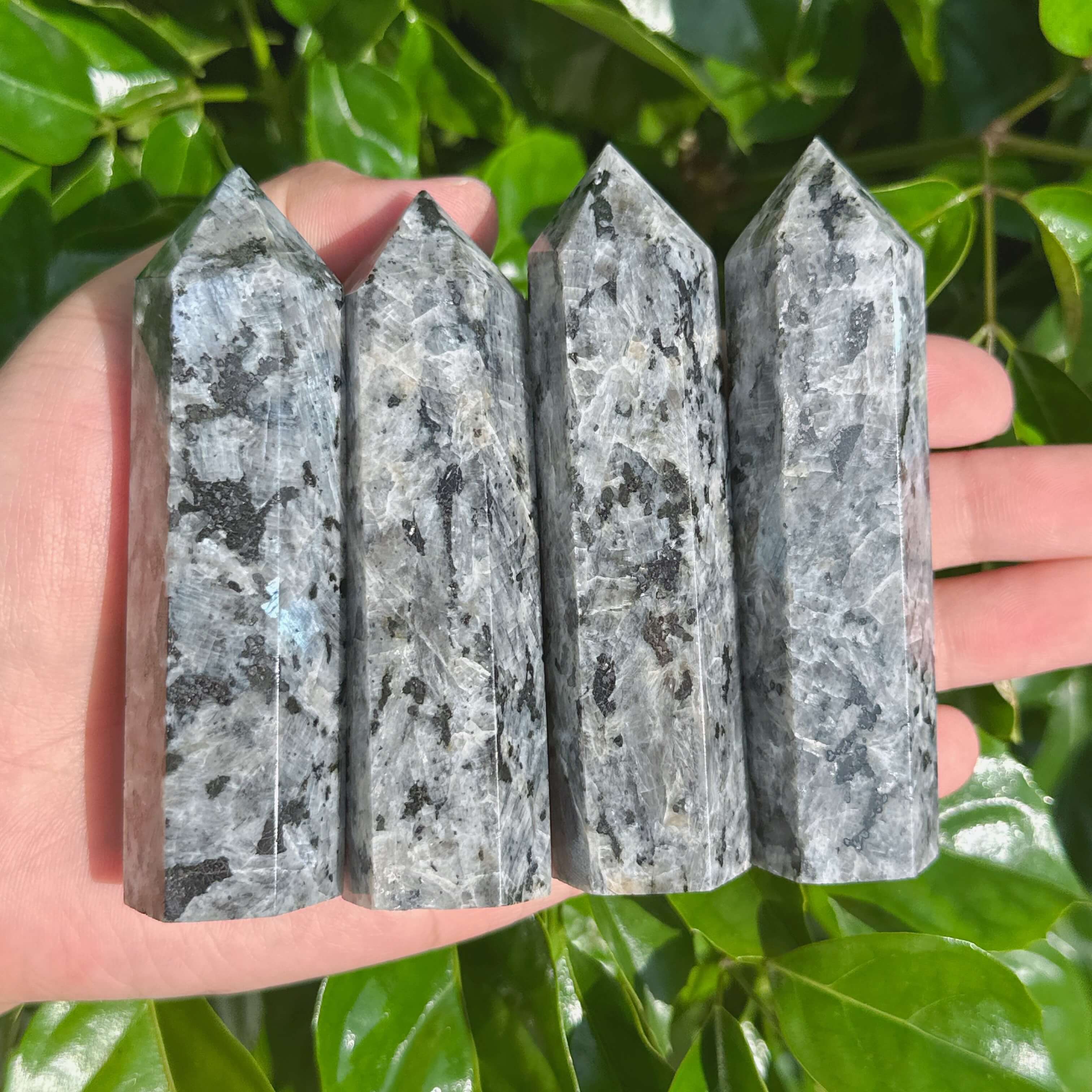 Larvikite crystal point with distinct black and gray striations.