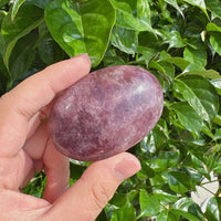 Lavender Rose Quartz Palm Stone in hand, showing its smooth, polished texture and calming lavender color. Great for healing and emotional peace.