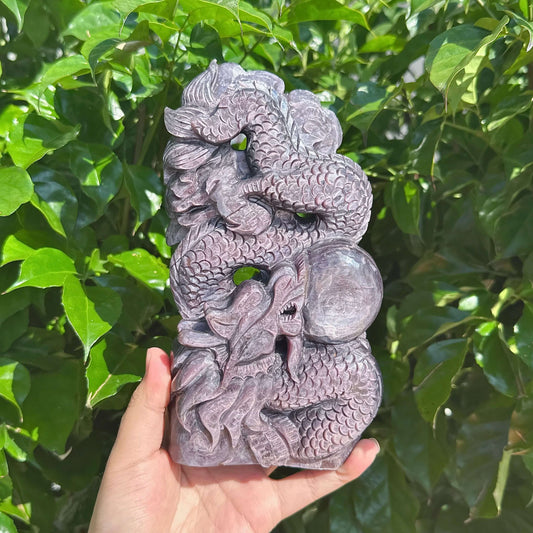 Lepidolite sculpture of a dragon surrounding a crystal ball with intricate details.