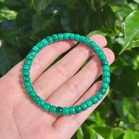Polished malachite beads bracelet showcasing green hues and smooth finish, perfect for healing and energy balance.