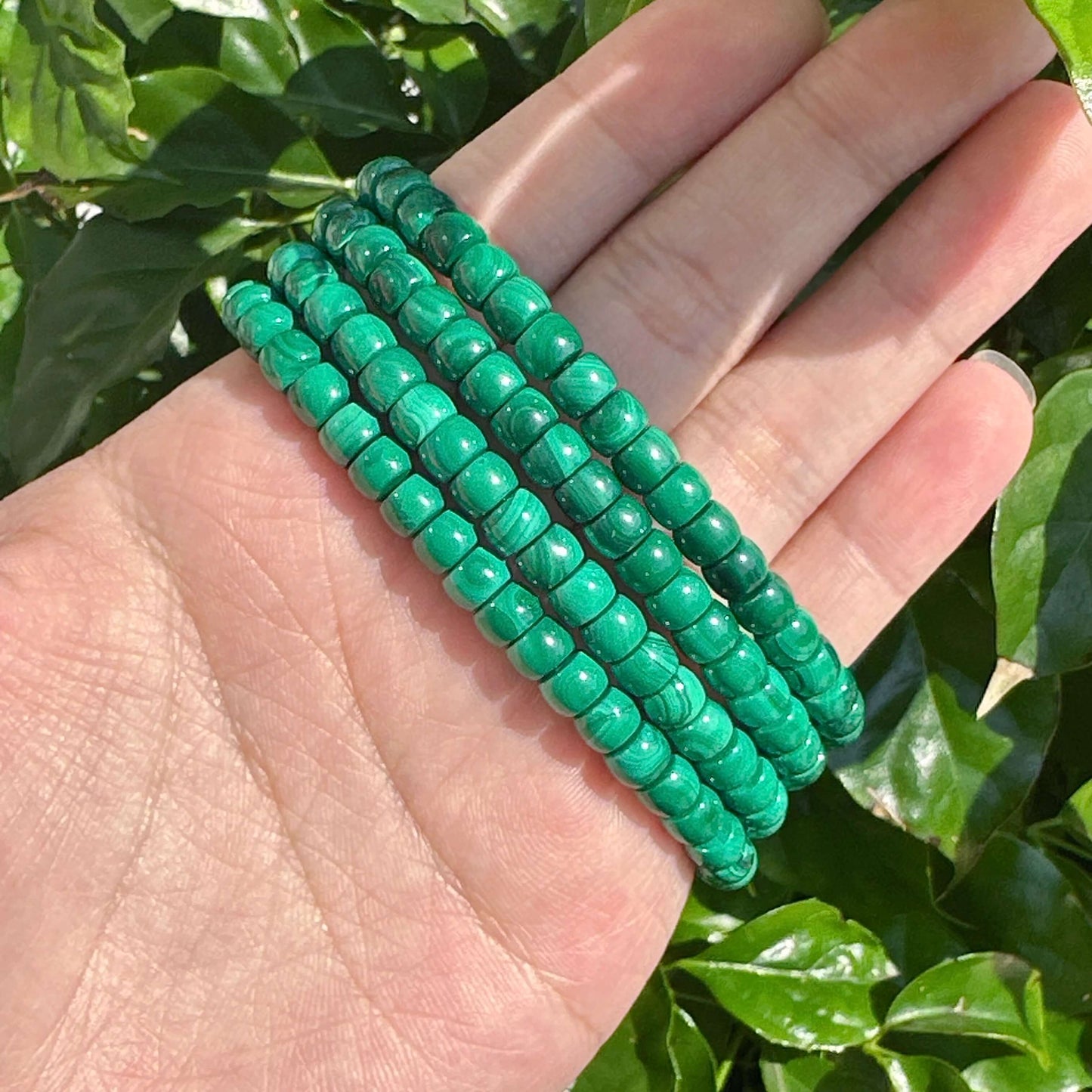 Stack of malachite bracelets, featuring smooth green stones known for emotional healing properties and personal growth.