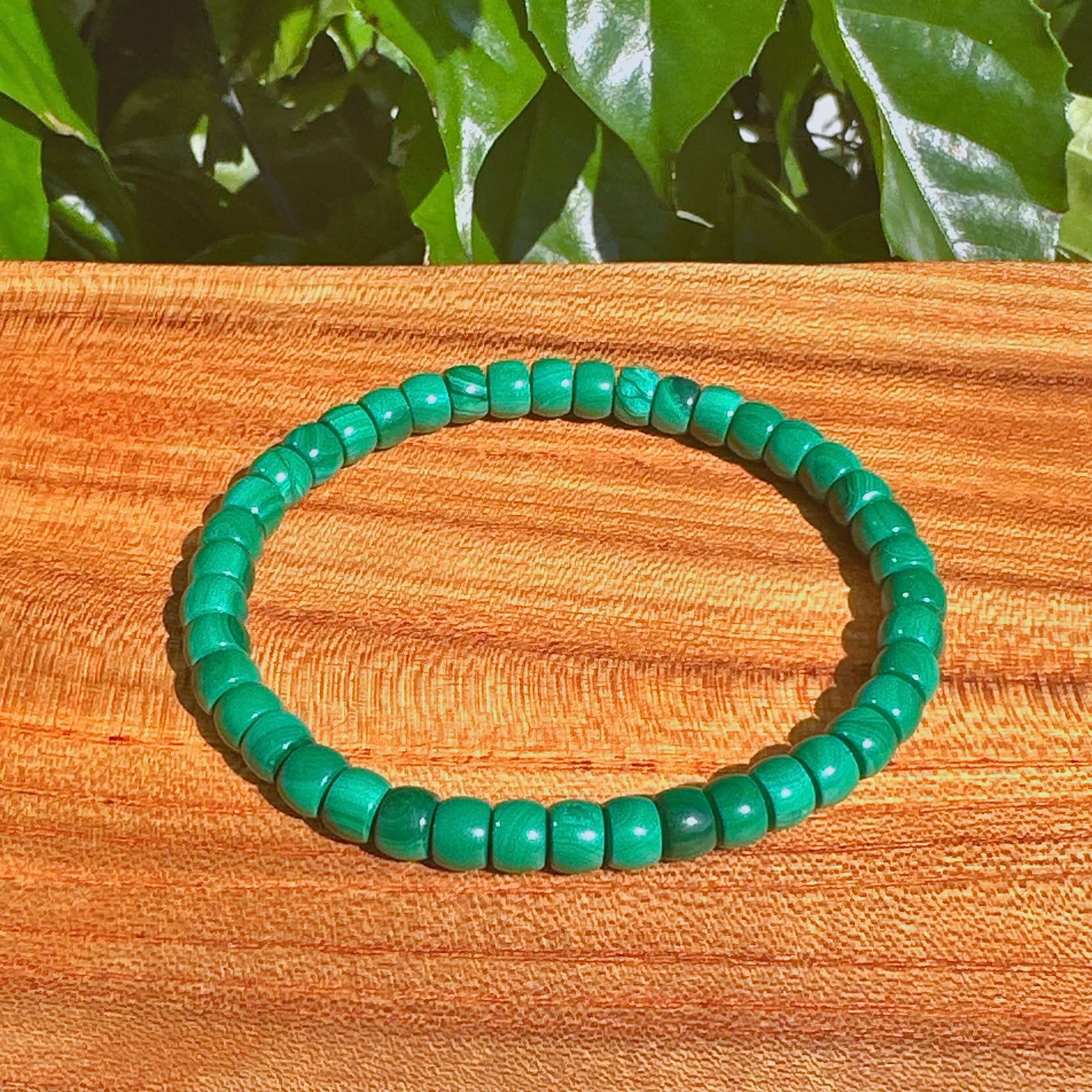 Close-up of malachite bracelet with smooth, polished beads, representing healing and positive energy.