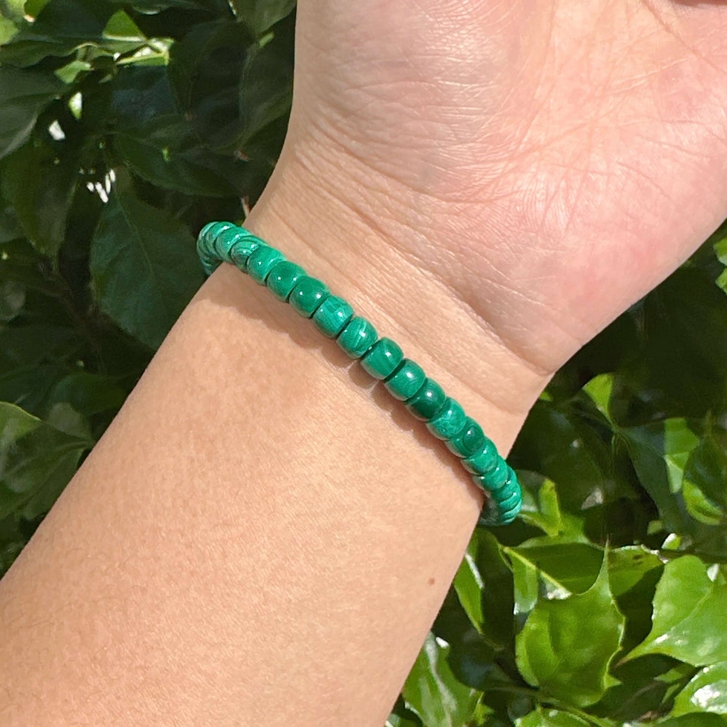 Multiple malachite bracelets stacked together, emphasizing their deep green color and grounding healing properties.