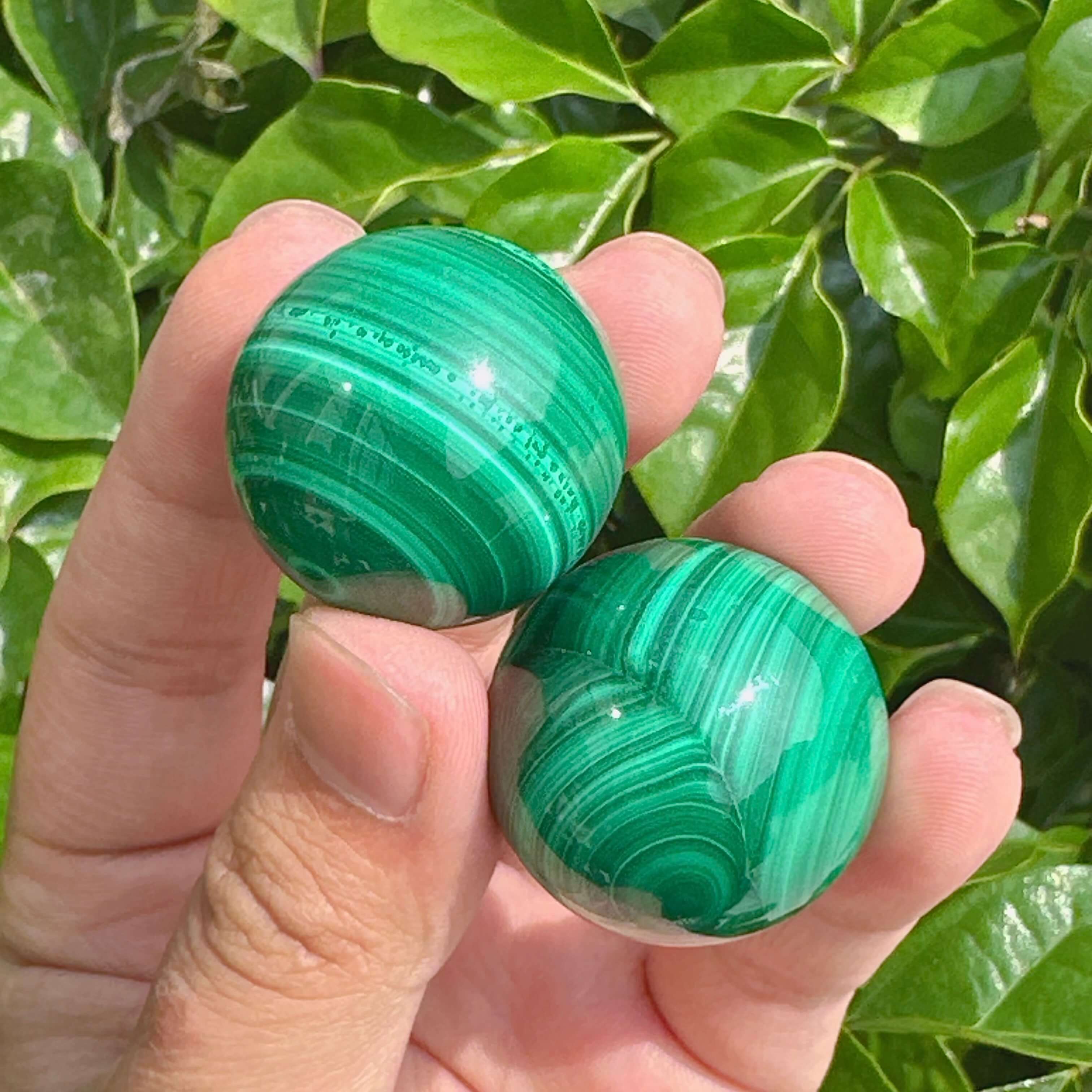 Gleaming malachite sphere with unique green striations and smooth texture