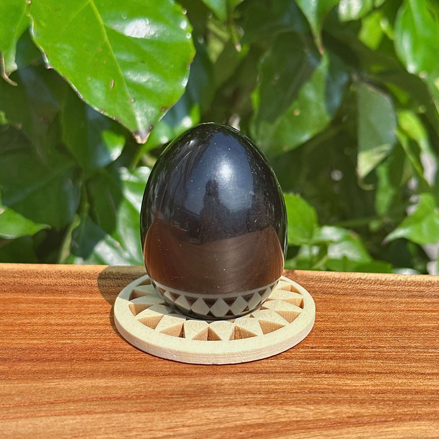 Exquisite obsidian egg carving captured in natural light, showcasing its polished finish and unique design.