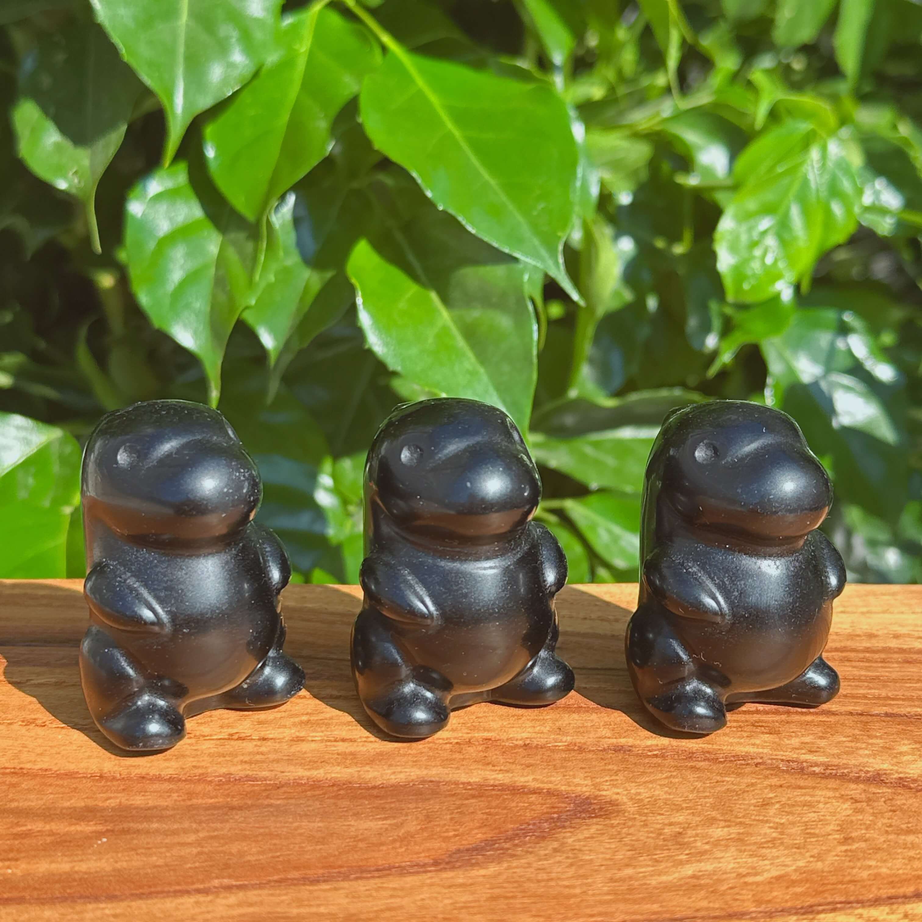 Three Obsidian Godzilla Carvings, showcasing their polished finishes and detailed craftsmanship side by side.