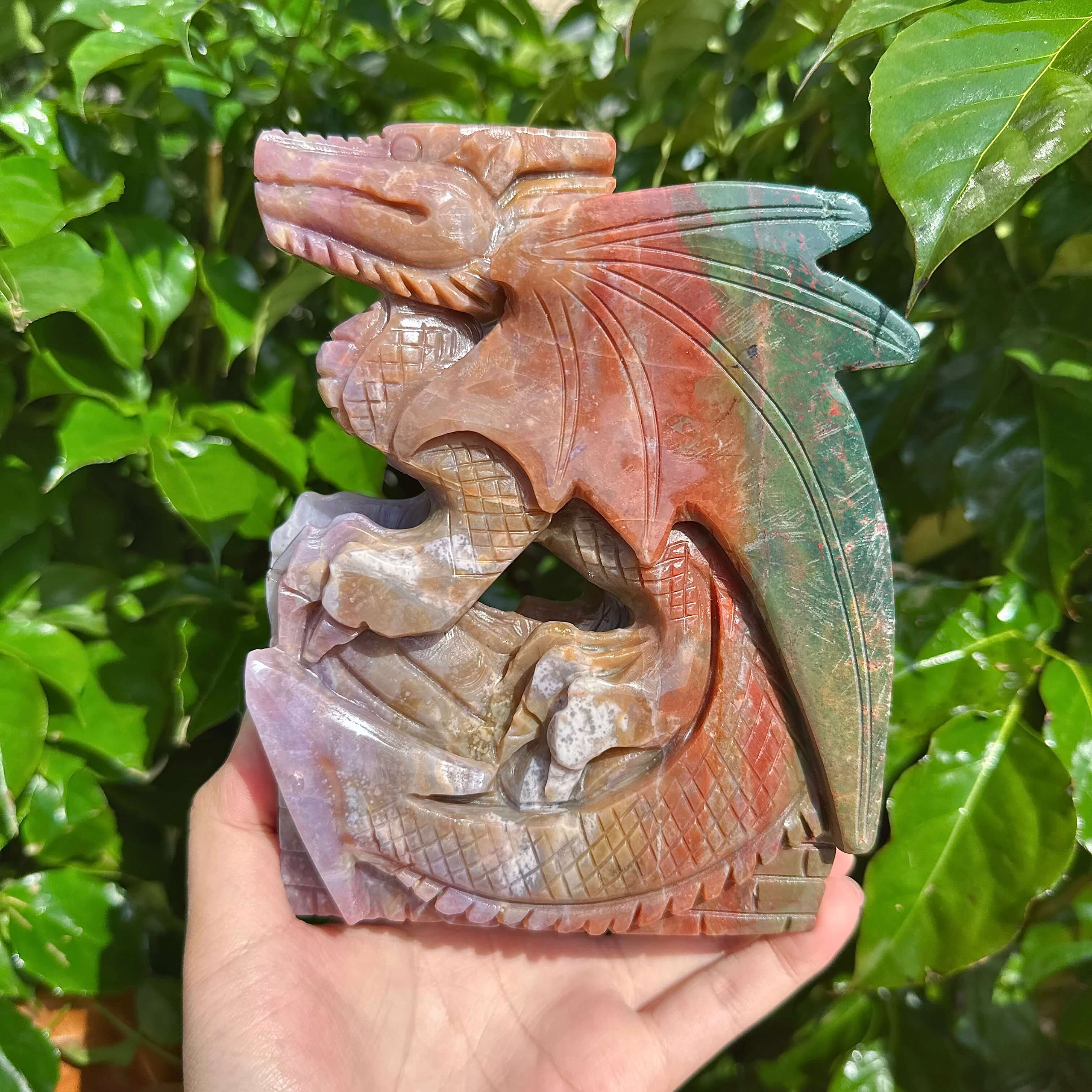 Ocean Jasper Dragon Carving held in hand, emphasizing the intricate details and craftsmanship.