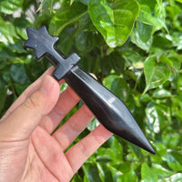 Close-up of Pentagram obsidian sword featuring a star-shaped hilt and sleek black blade.