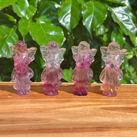 Front view of Rainbow Fluorite angel carving highlighting the intricate wings and tranquil pose.