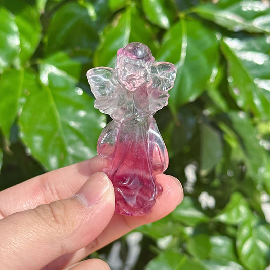 A pair of Rainbow Fluorite angel carvings, symbolizing harmony and protection with their intricate design