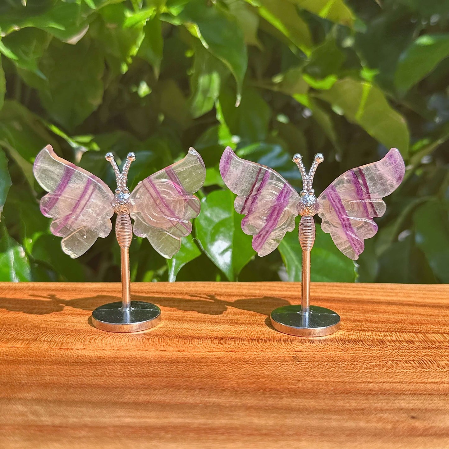 Elegant Rainbow Fluorite Butterfly crystal sculpture with intricate wings, showcasing vibrant purple and green natural coloring.